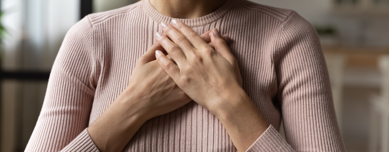 Mulher com as mãos no peito, simbolizando o regresso ao corpo e à própria intuição.