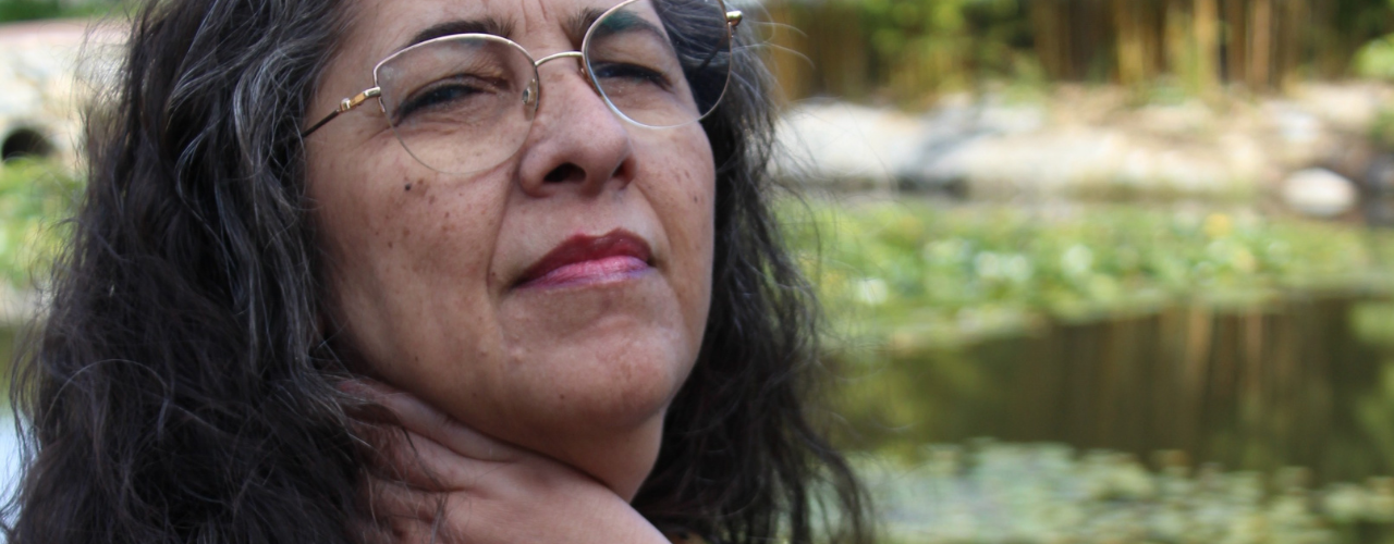Liliana Vieira com olhar sereno e determinado em fundo natural — sobre como usar o pêndulo para tomar decisões difíceis